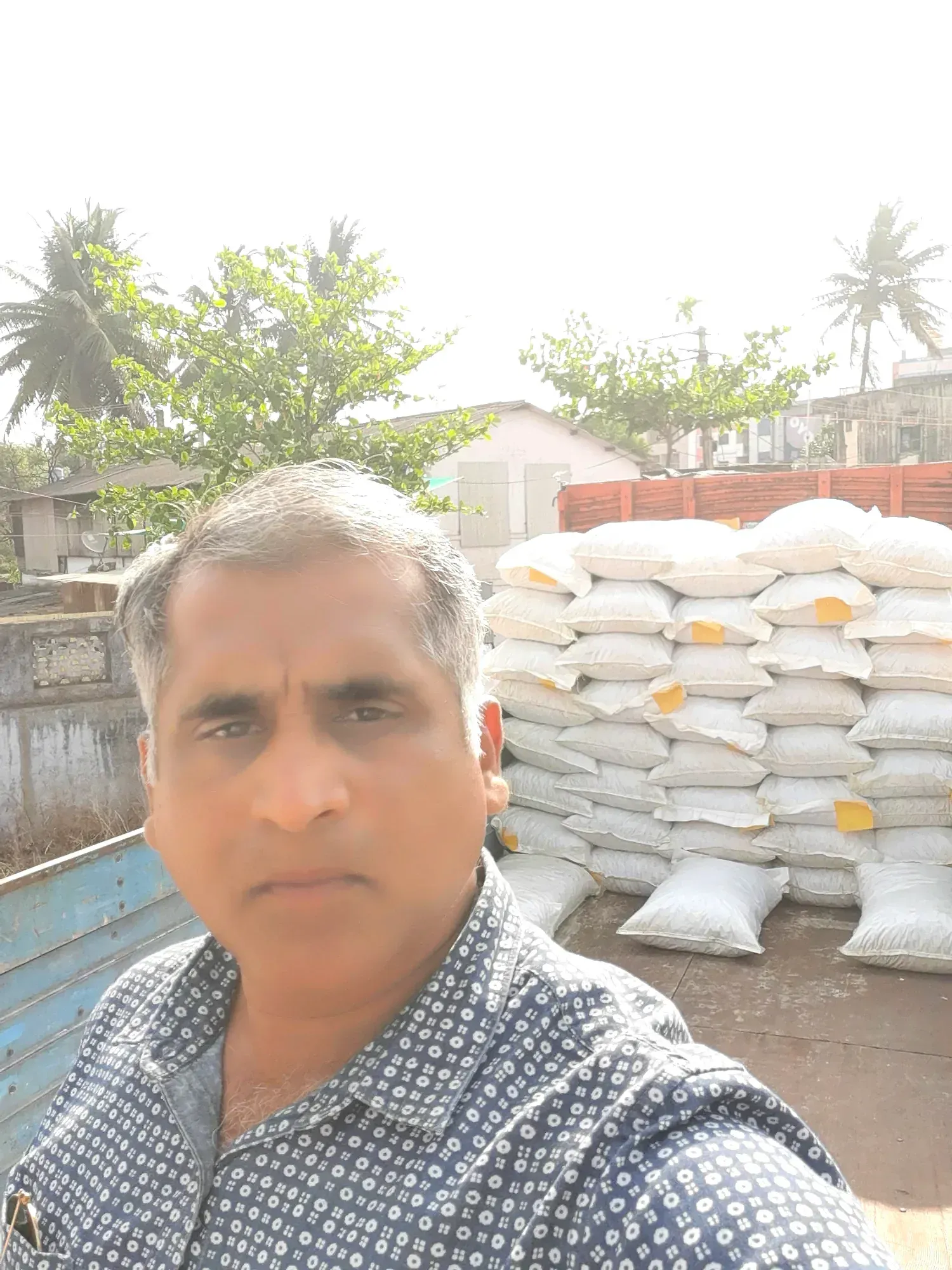 The procurement lead at the mill yard in front of stacked filled sacks