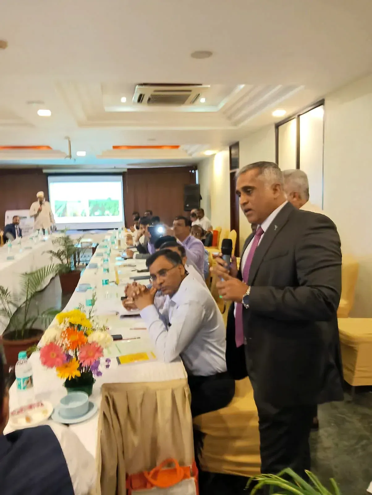 Captain Mahesh Khochare presenting to officials seated around a conference table