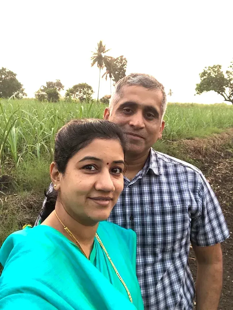 Ashwini Khochare and the Captain at the edge of a sugarcane field at dusk, palms on the horizon