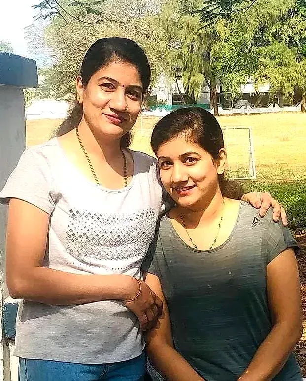 Twin sisters Ashwini Khochare and Avanti Raut side by side outdoors, an arm around each other
