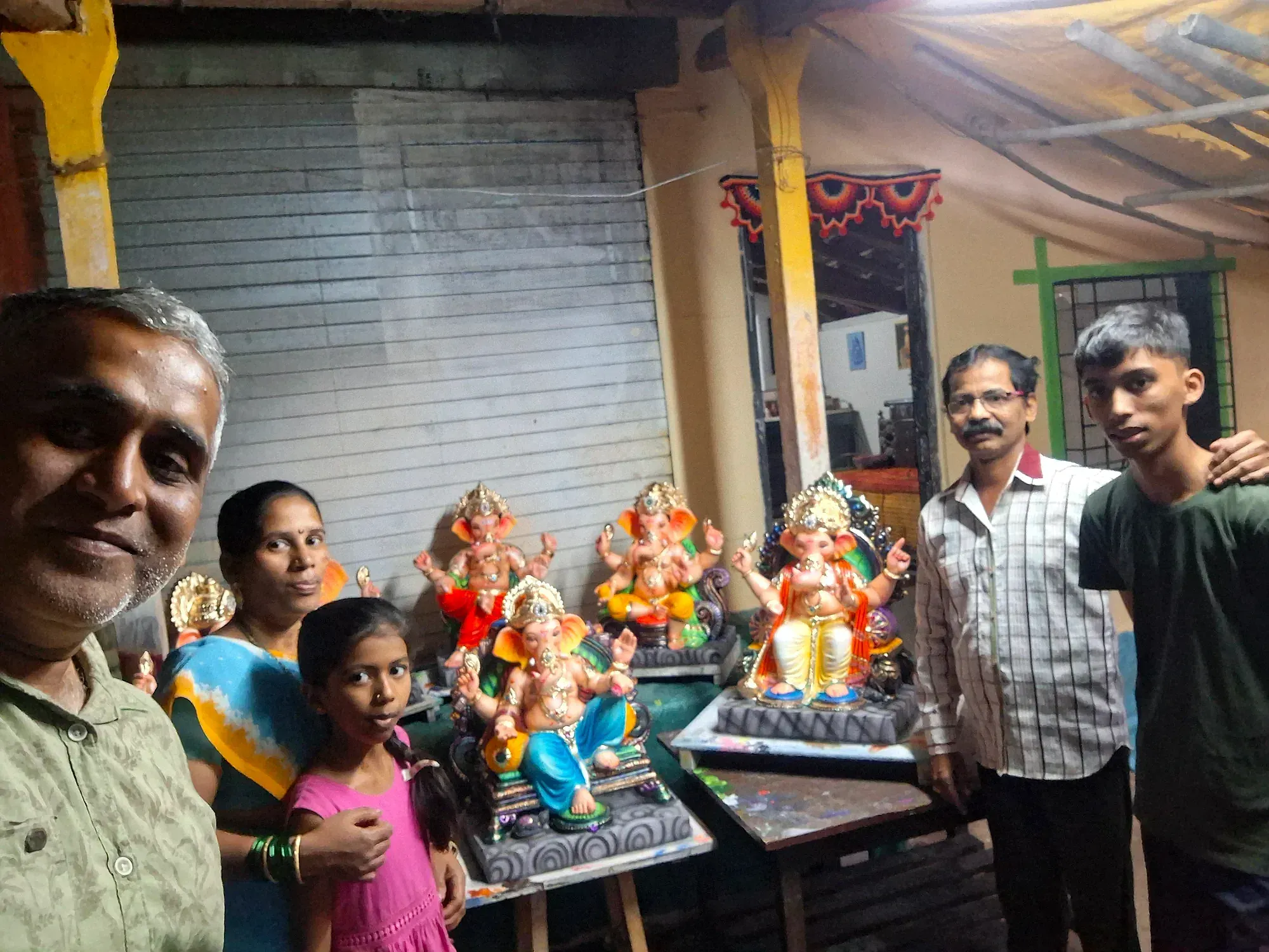 The family with local artisans beside finished idols at Kankavli
