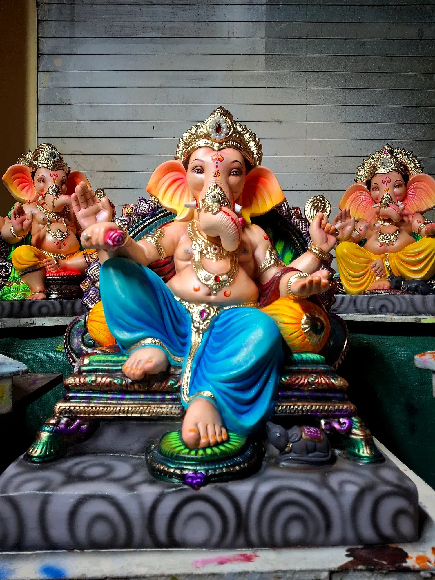 A row of painted Ganesh idols lined up in a workshop