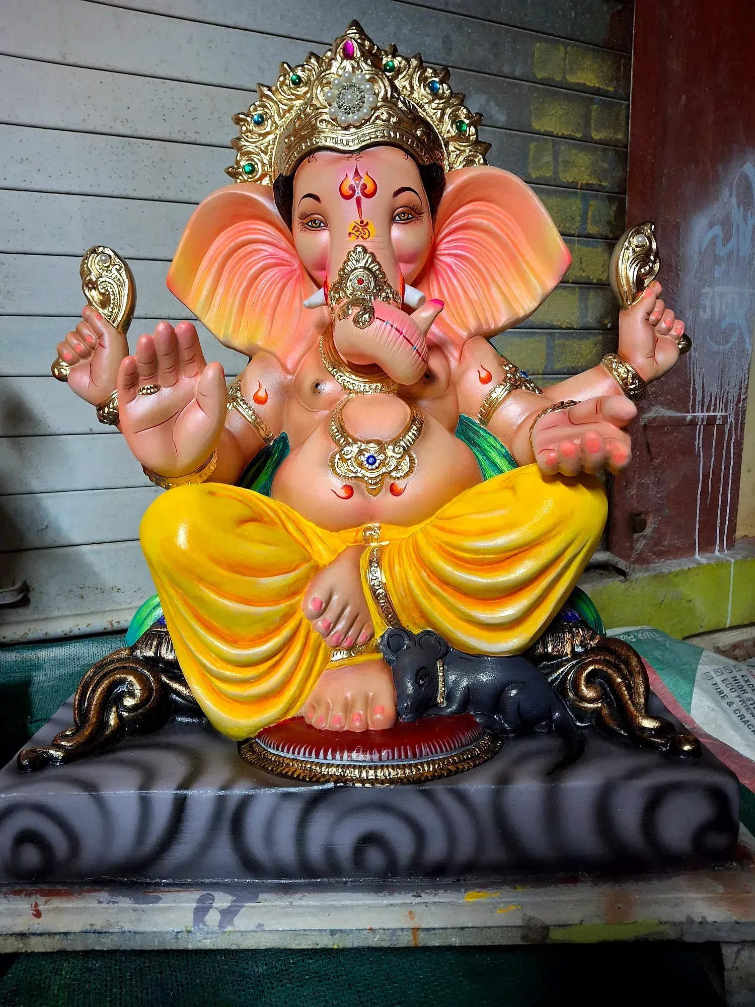 Painted Ganesh idols standing in the artisan workshop